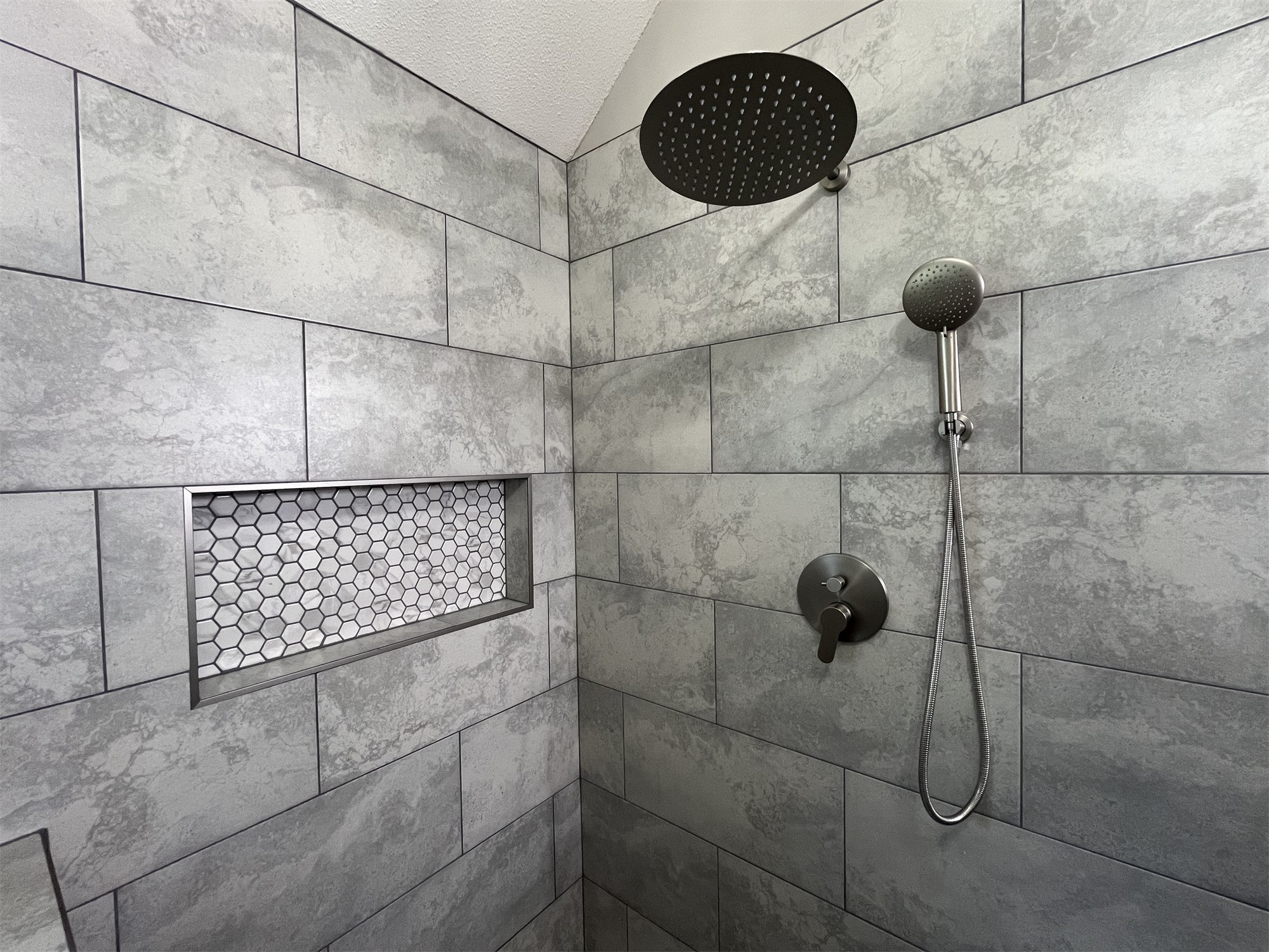 Completed shower with gray tile and black fixtures