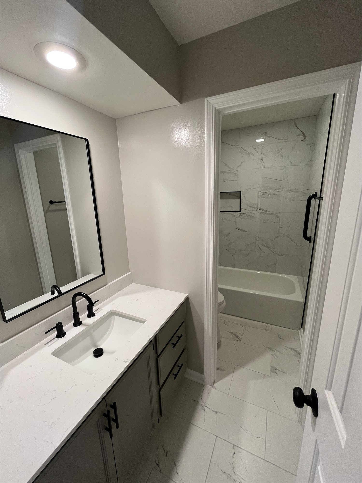 Completed bathroom with a glass shower and dark vanity