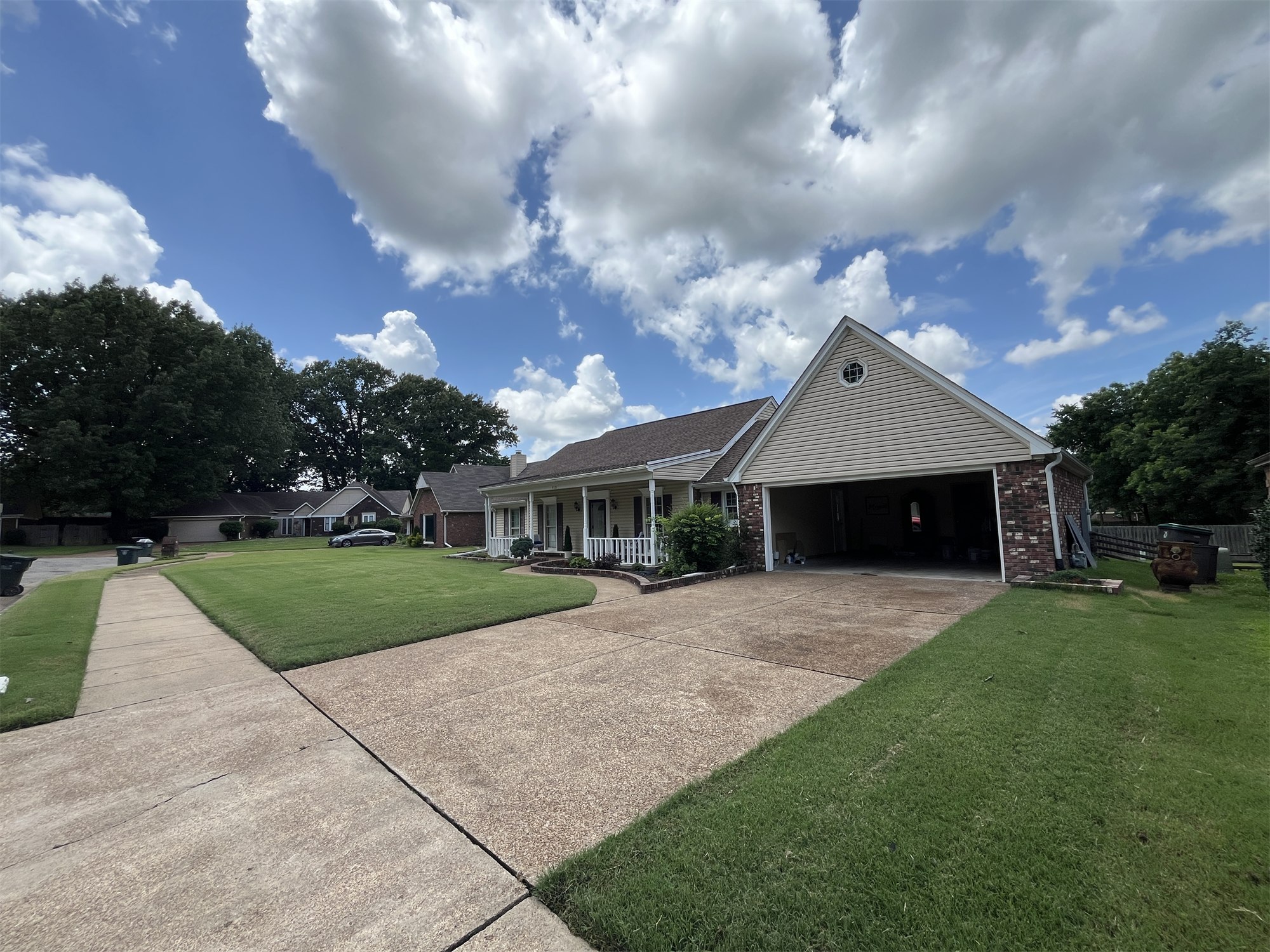 Cleaned concrete driveway and walkway in front of a house